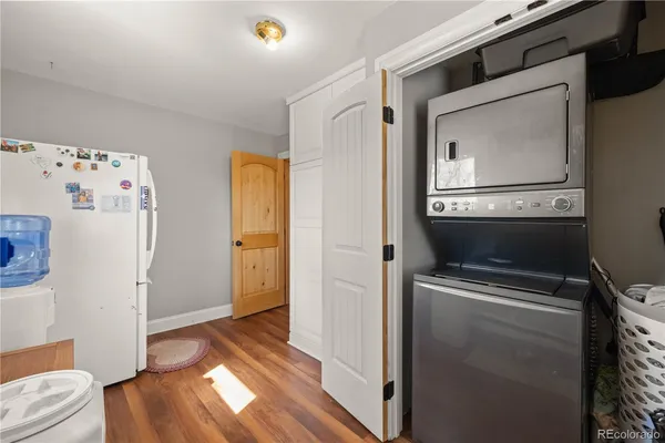 a utility room with wooden floor washer and dryer