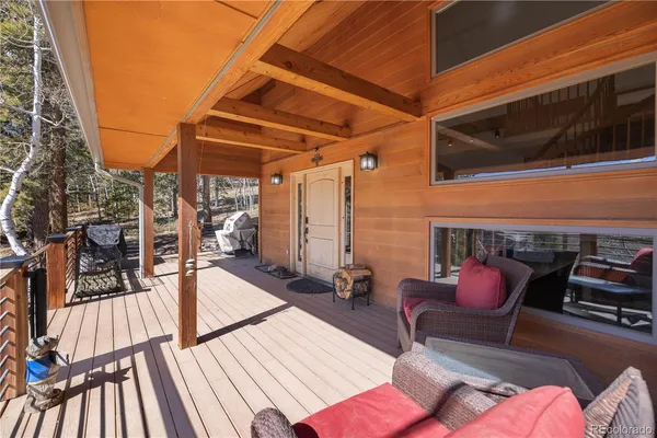 a view of a patio with a dining table and chairs with wooden floor