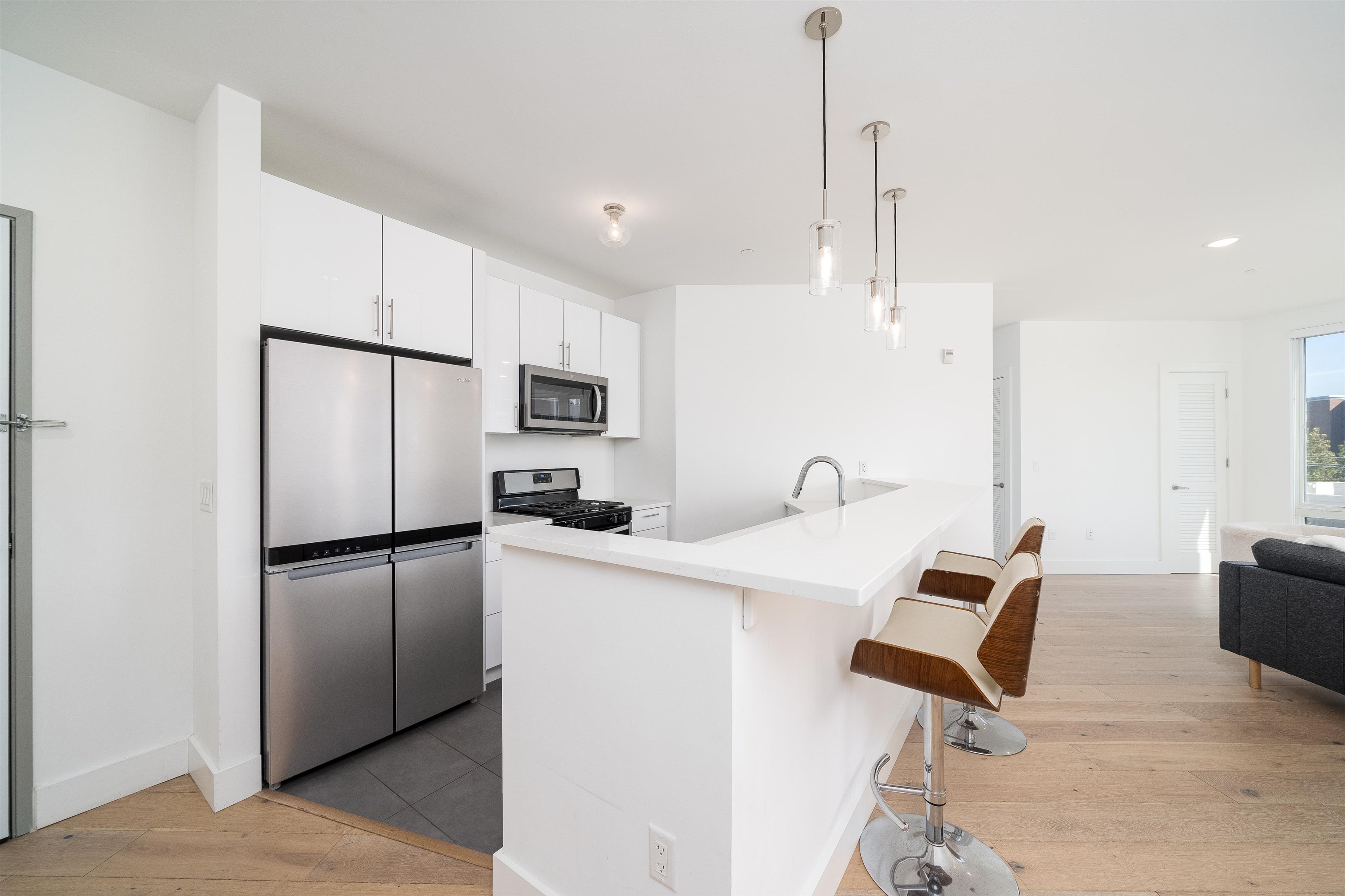 8621 River Road, Unit 4A North Bergen, NJ 07047 - Photo 9 of 42 a kitchen with stainless steel appliances kitchen island a refrigerator sink and stove
