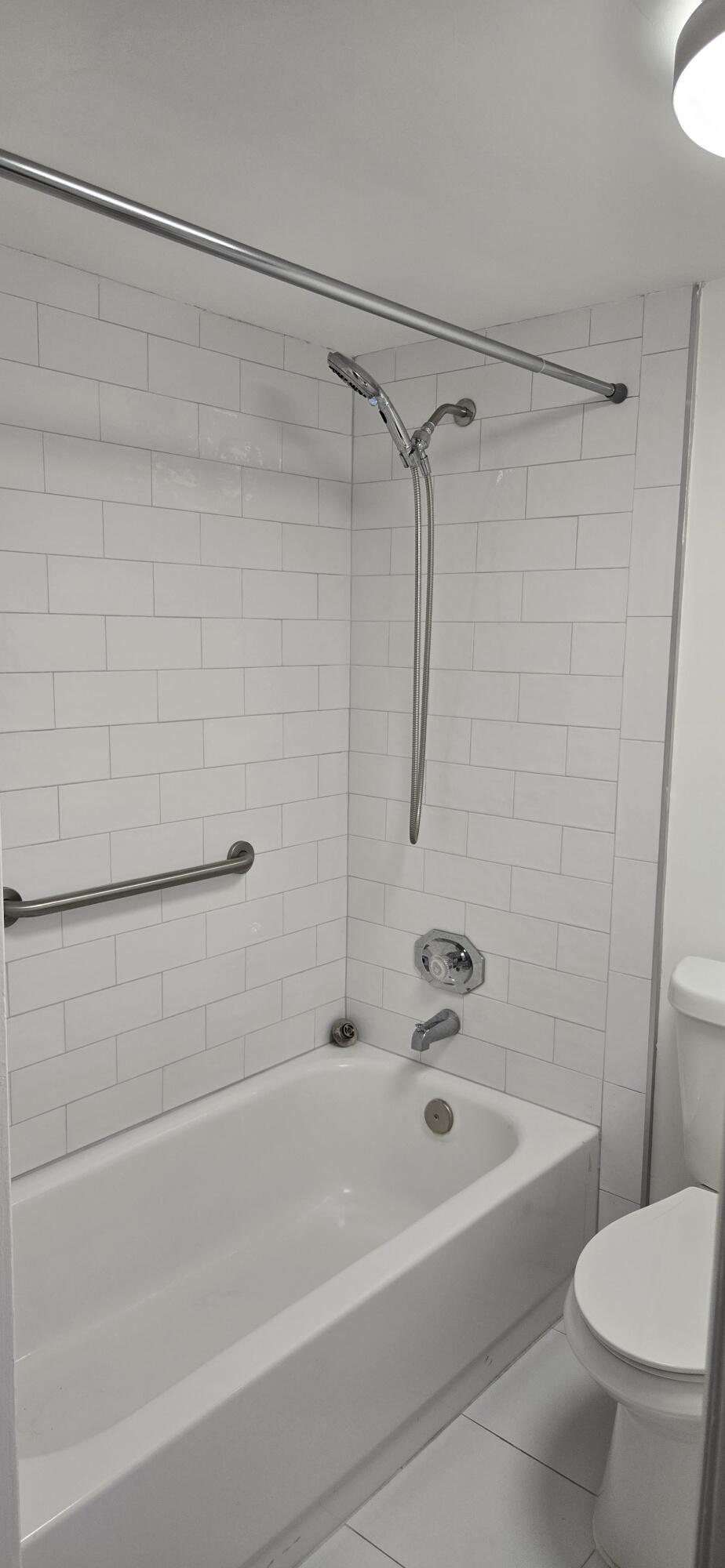 497 Flanders K Delray Beach, FL 33484 - Photo 11 of 15 a bathroom with a shower a toilet and a bathtub