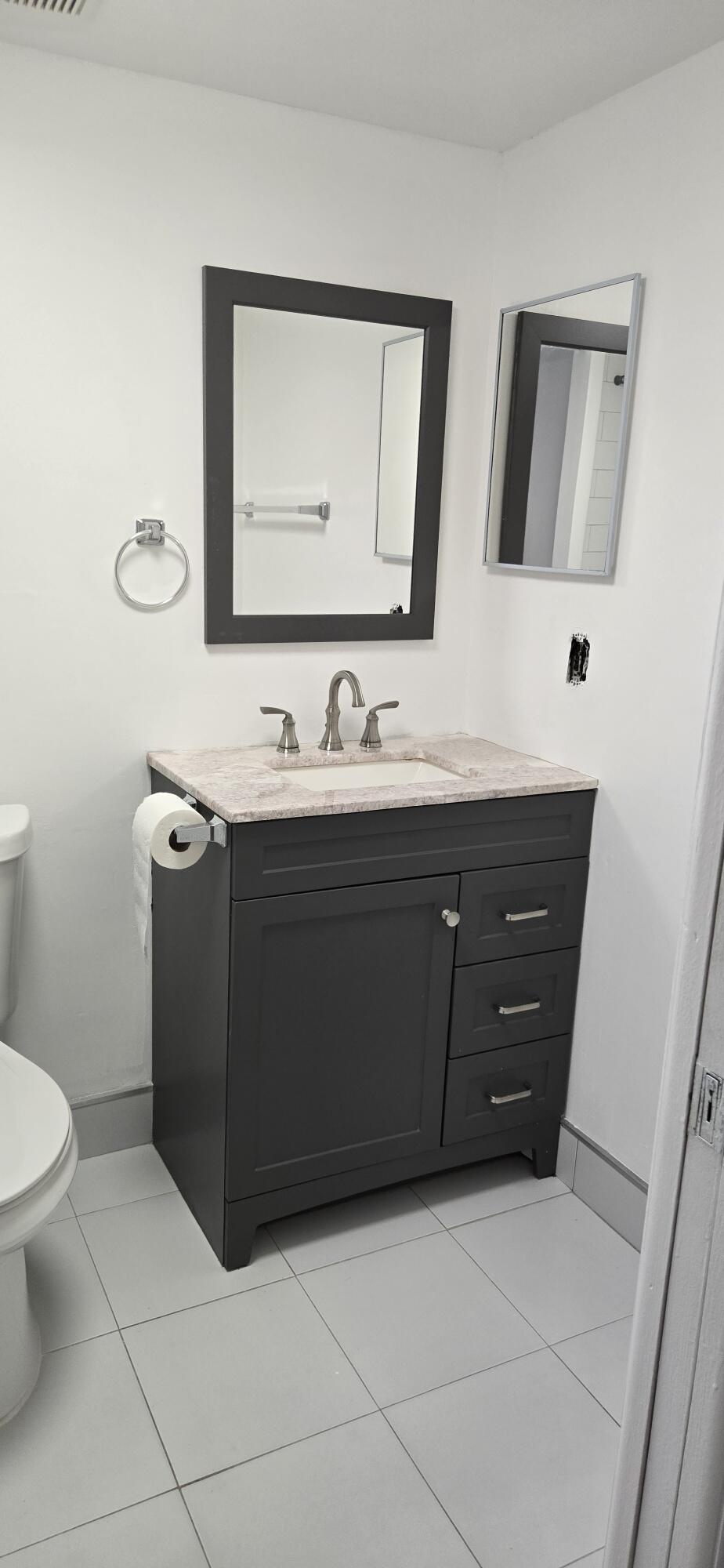 497 Flanders K Delray Beach, FL 33484 - Photo 13 of 15 a bathroom with a sink vanity and mirror