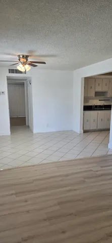 a view of a kitchen with white cabinets and a wooden floor