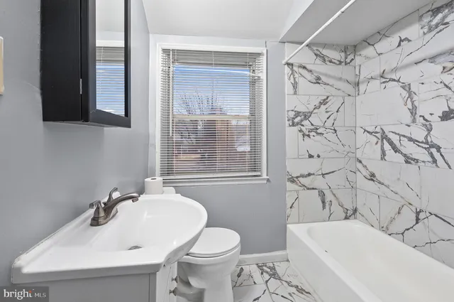 a bathroom with a sink and mirror with bathtub