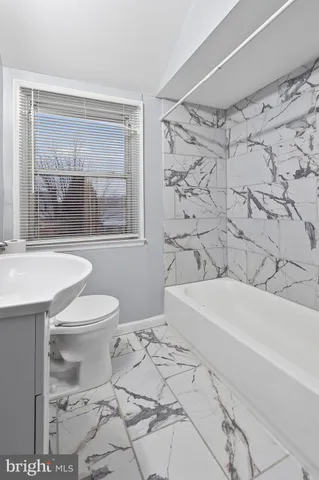 a bath room with a toilet a bath tub and a shower