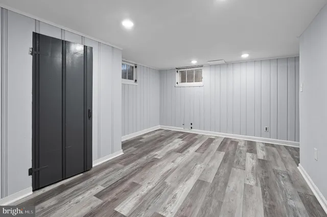 a view of an empty room with wooden floor and entryway