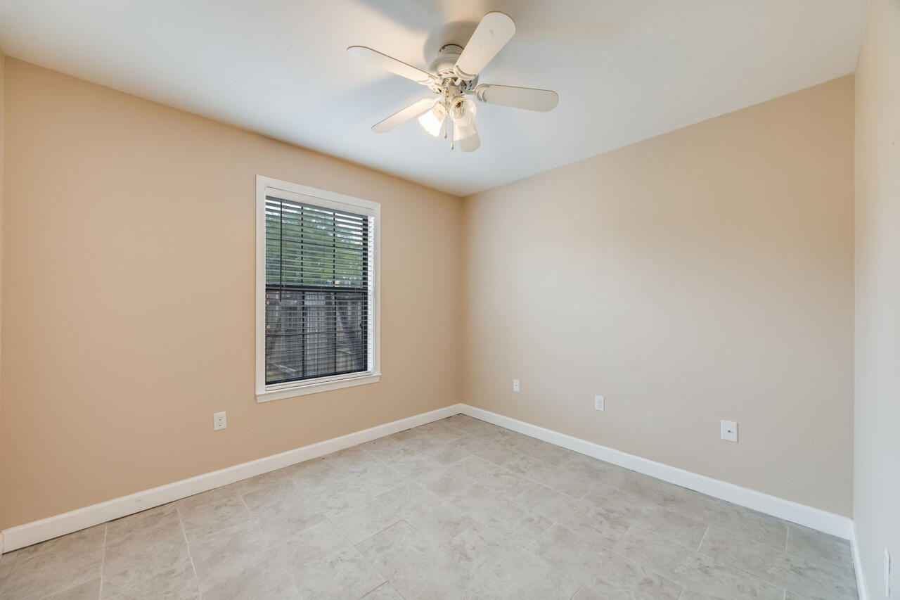 519 Krest Drive Crestview, FL 32536 - Photo 22 of 37 an empty room with a chandelier fan and windows