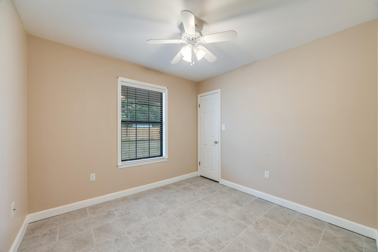519 Krest Drive Crestview, FL 32536 - Photo 24 of 37 an empty room with windows and chandelier fan