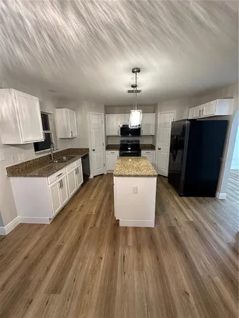 a kitchen with granite countertop a sink and a stove