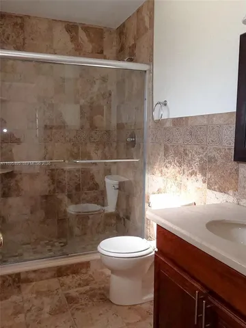 a bathroom with a toilet a sink and shower
