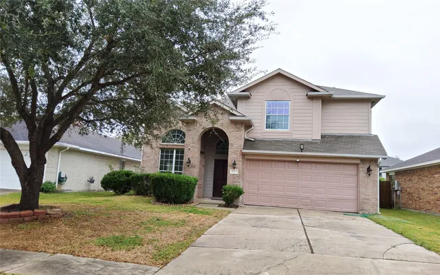 a front view of a house with a yard and trees