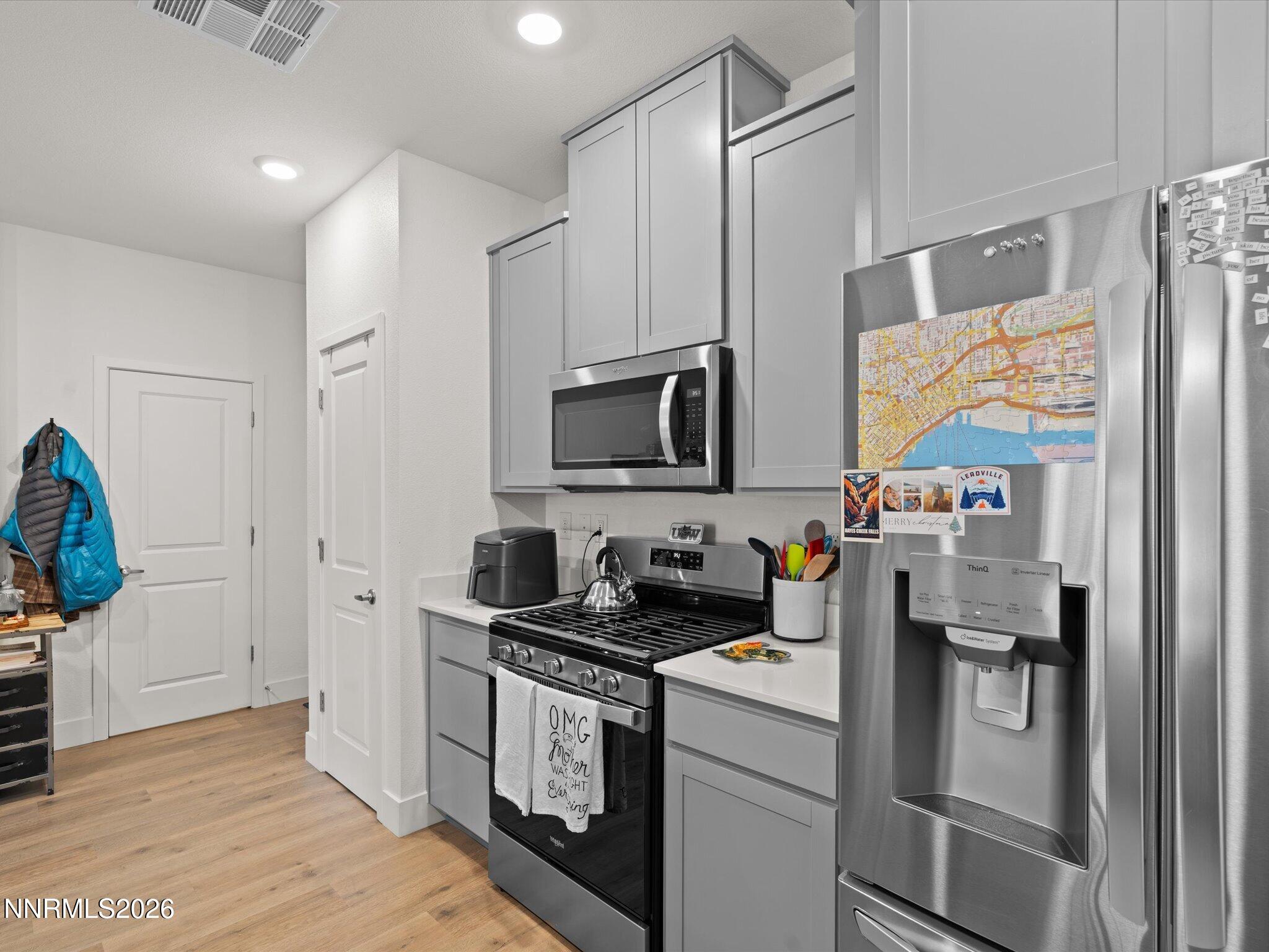 4233 Fawnridge Place Reno, NV 89523 - Photo 11 of 30 a kitchen with stainless steel appliances a refrigerator a sink a stove top oven a counter space and cabinets