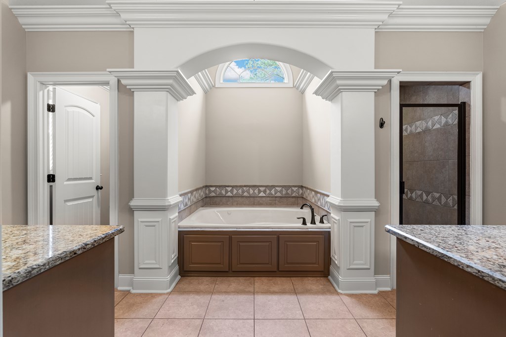 8026 Splendor Way Columbus, GA 31904 - Photo 18 of 44 a bathroom with a granite countertop sink a mirror and a bathtub