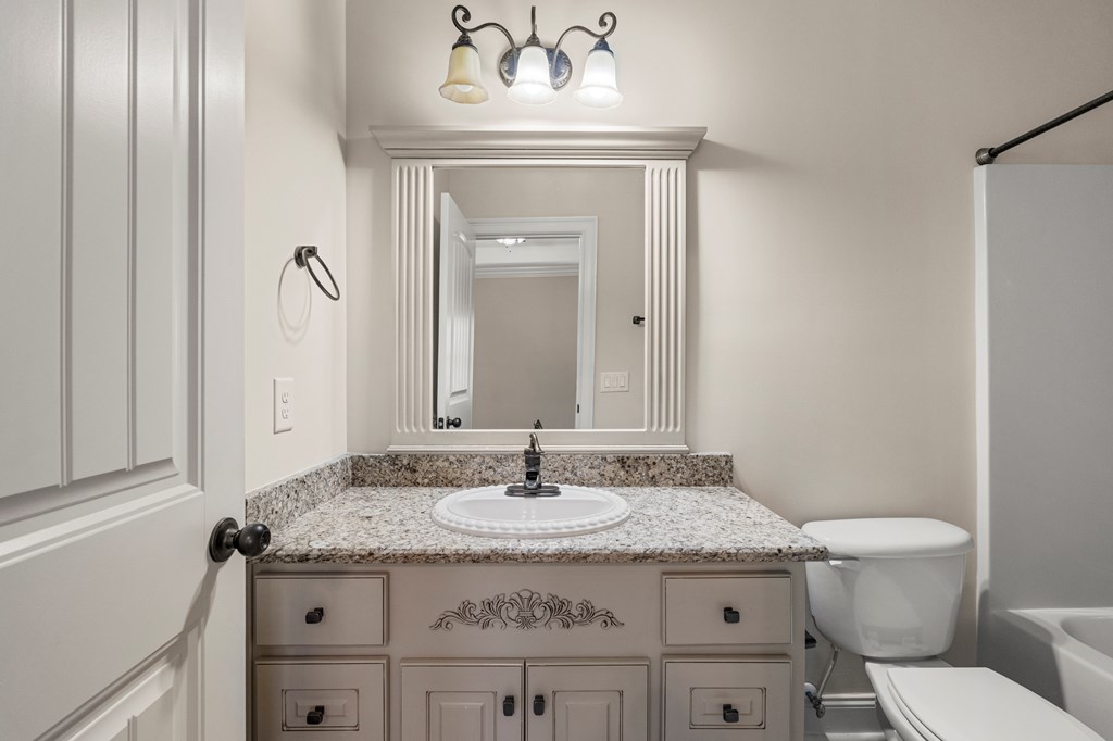 8026 Splendor Way Columbus, GA 31904 - Photo 30 of 44 a bathroom with a granite countertop sink a toilet and a mirror
