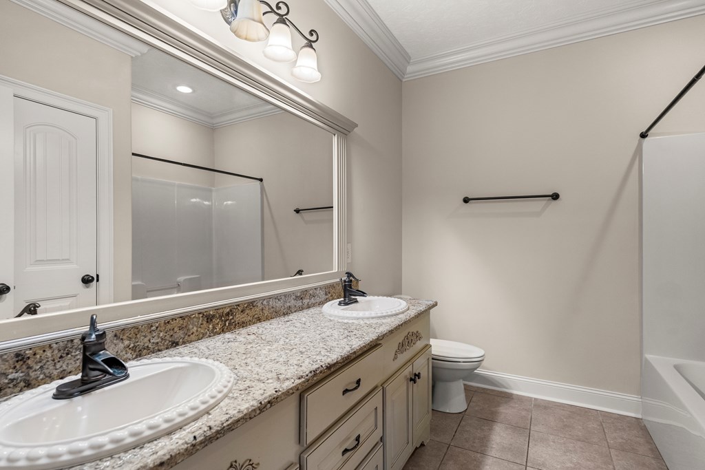 8026 Splendor Way Columbus, GA 31904 - Photo 32 of 44 a bathroom with a granite countertop sink a toilet and a mirror
