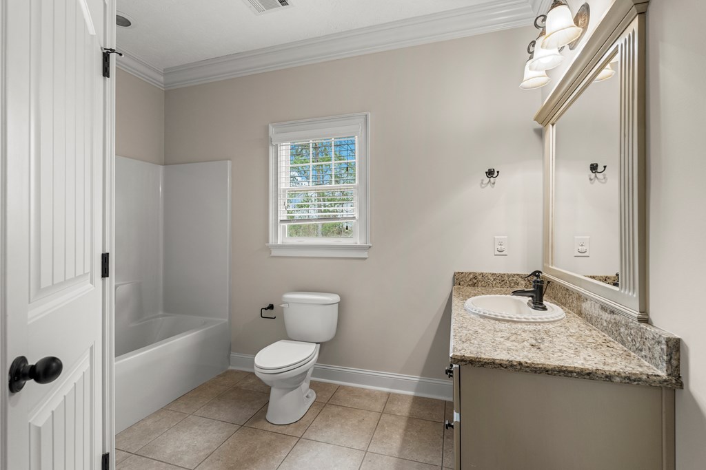 8026 Splendor Way Columbus, GA 31904 - Photo 34 of 44 a bathroom with a granite countertop sink a toilet a mirror and shower
