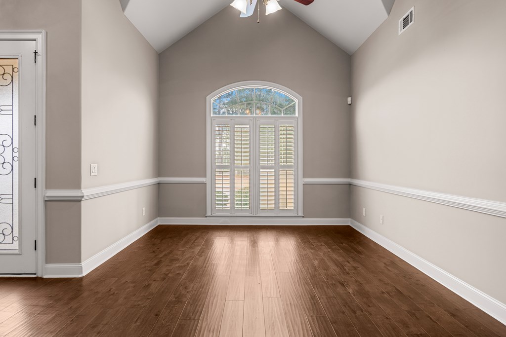 8026 Splendor Way Columbus, GA 31904 - Photo 7 of 44 an empty room with wooden floor a exposed radiator and a window
