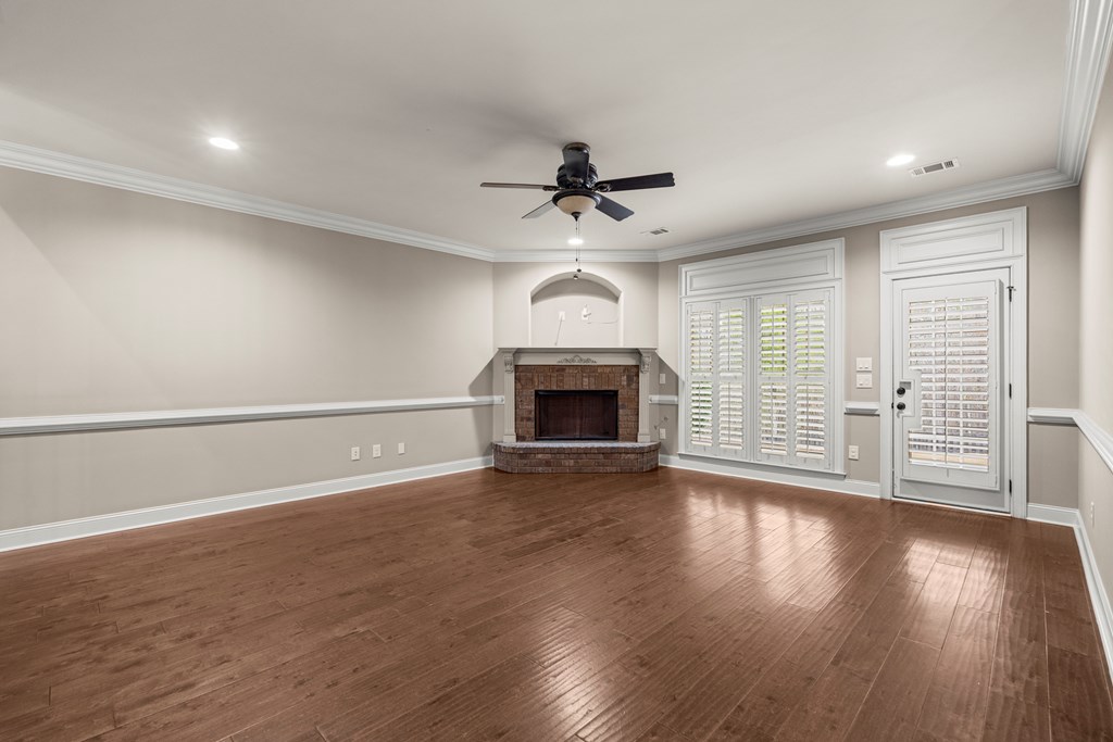 8026 Splendor Way Columbus, GA 31904 - Photo 10 of 44 an empty room with wooden floor fireplace and windows
