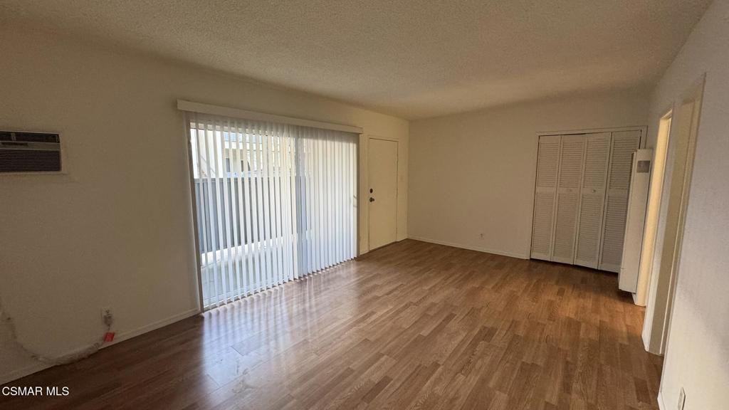 13507 Victory Boulevard, Unit 2 Van Nuys, CA 91401 - Photo 5 of 10 an empty room with wooden floor and windows