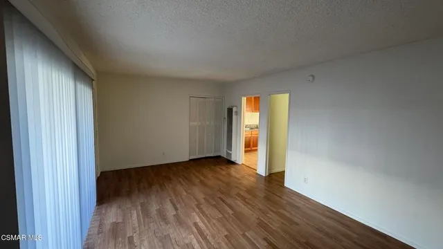 an empty room with wooden floor and closet
