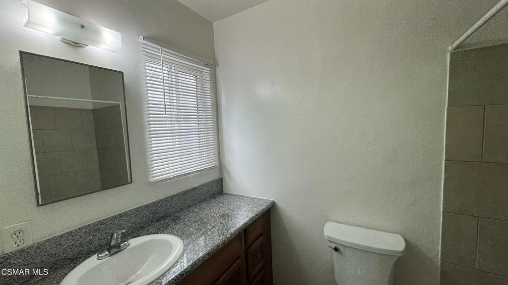 13507 Victory Boulevard, Unit 2 Van Nuys, CA 91401 - Photo 10 of 10 a bathroom with a granite countertop sink toilet and mirror