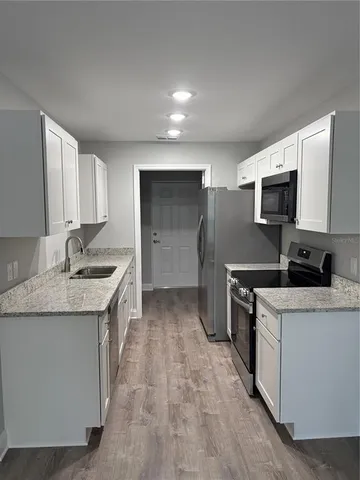 a kitchen with a sink stove and refrigerator