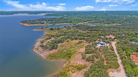 an aerial view of a house with a yard and large trees
