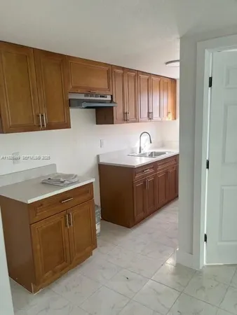 a kitchen with a sink and a stove top oven