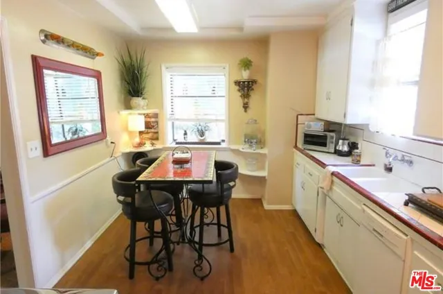 a kitchen with a dining table chairs and window