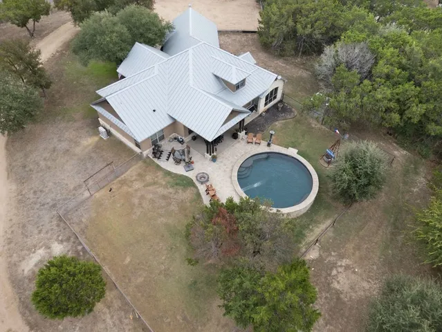 an aerial view of a house with a yard and trees