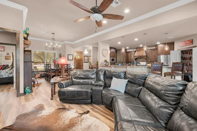 a kitchen with stainless steel appliances granite countertop a refrigerator a stove and a sink with wooden floor