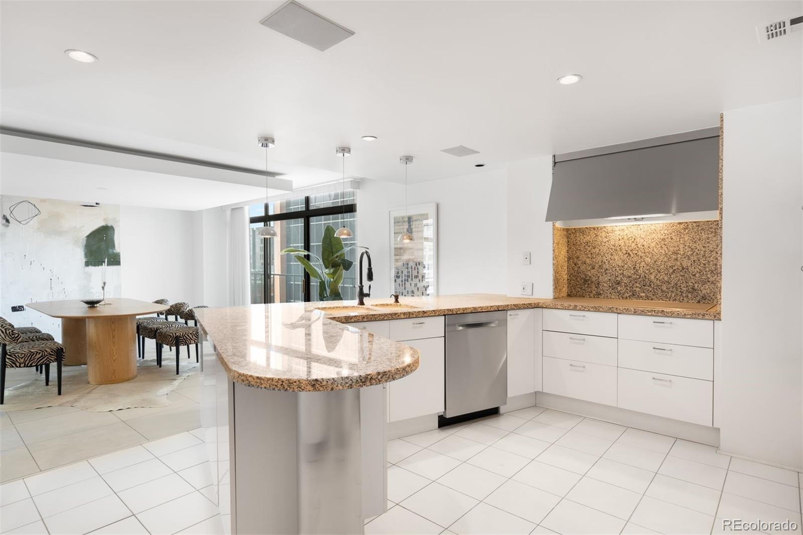 1777 Larimer Street, Unit 710 Denver, CO 80202 - Photo 14 of 47 a large white kitchen with a white cabinets and chairs