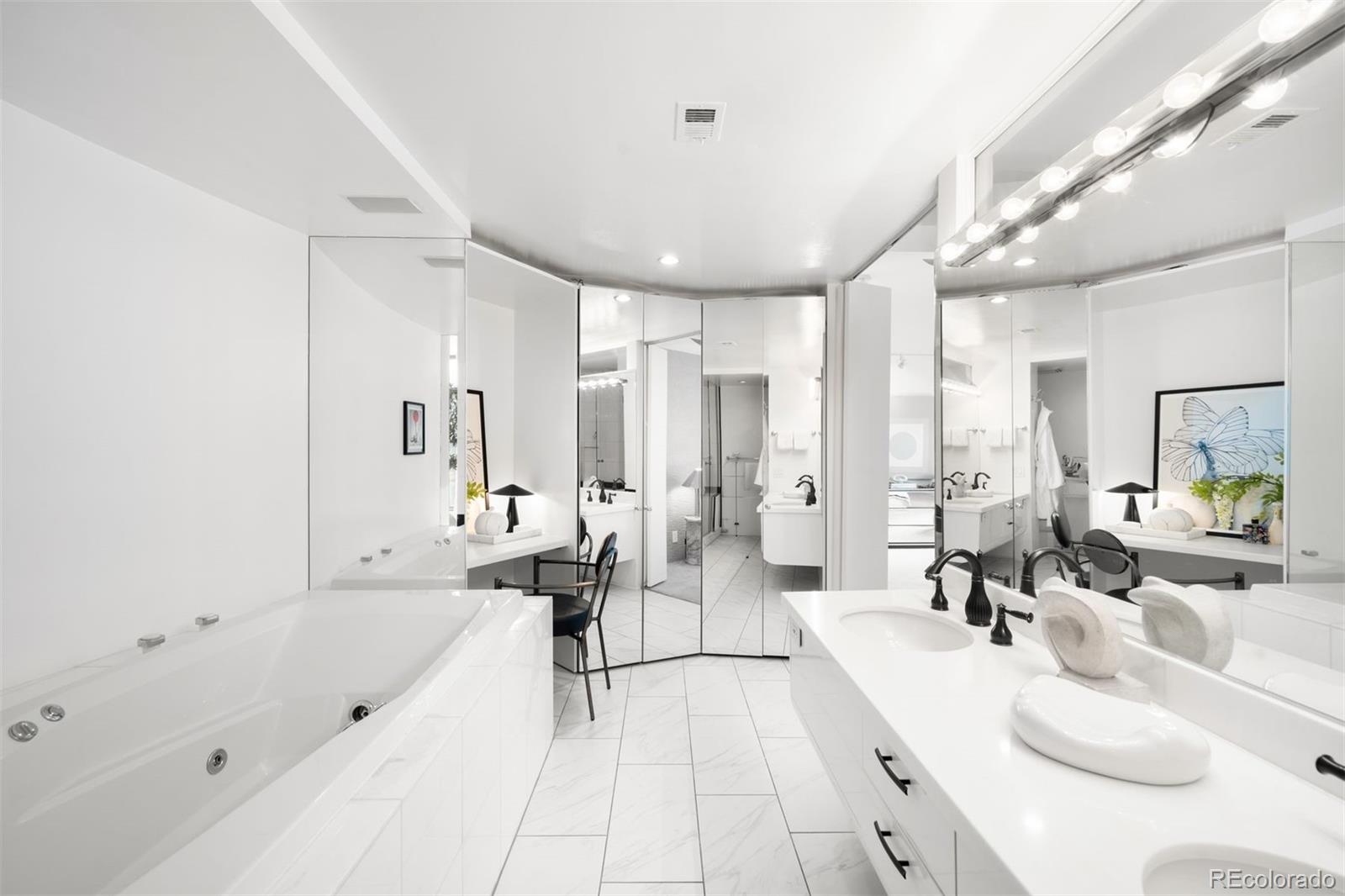 1777 Larimer Street, Unit 710 Denver, CO 80202 - Photo 30 of 47 a large white bathroom with a tub a double vanity sink a mirror and a shower