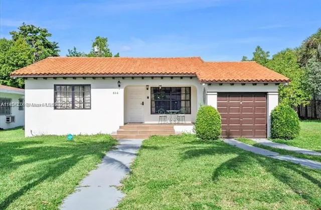 a front view of a house with a garden