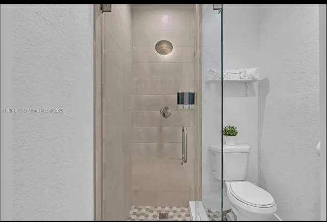 a bathroom with a shower a toilet and sink