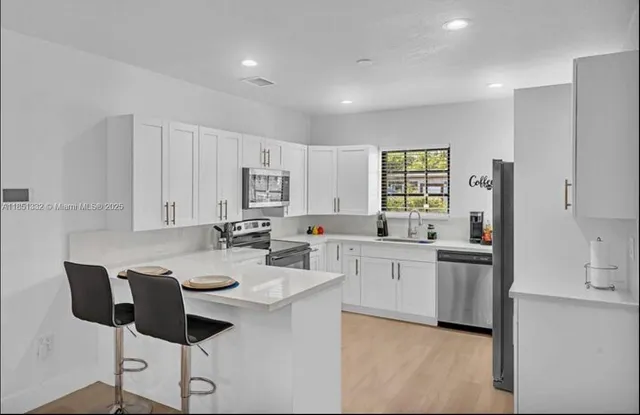 a kitchen with a sink cabinets and chairs