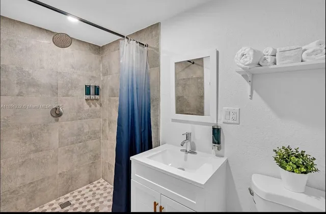 a bathroom with a sink toilet and shower