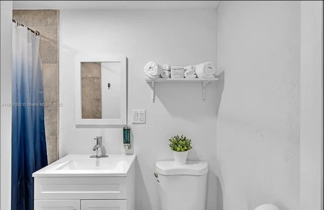 a bathroom with a sink mirror and toilet