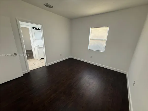 an empty room with wooden floor and a window