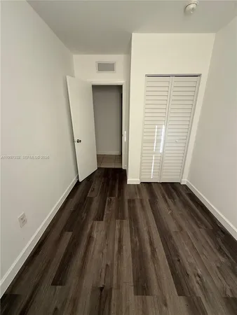 a view of a room with wooden floor and white walls