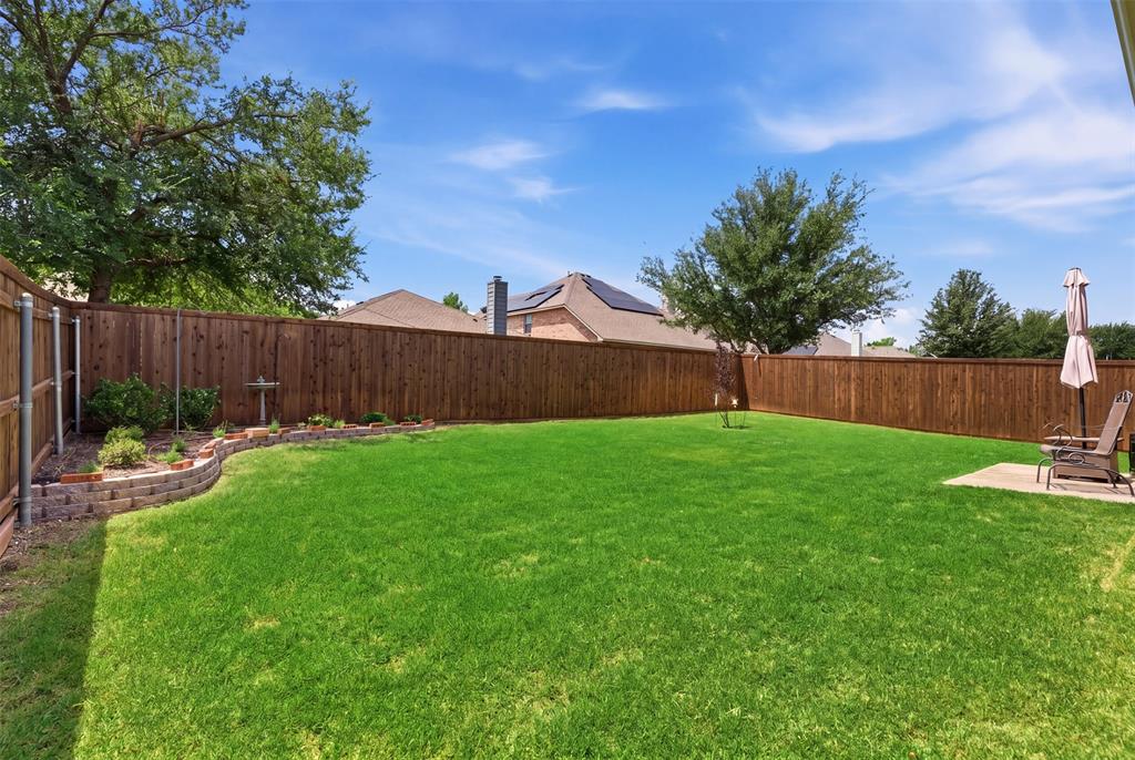 5491 Exeter Drive Prosper, TX 75078 - Photo 3 of 20 a view of a backyard with table and chairs a barbeque and wooden fence