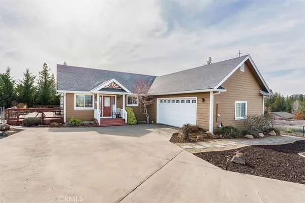 a view of a house with backyard and trees in the background