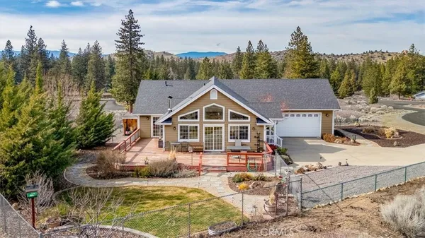 a view of a house with backyard and sitting area