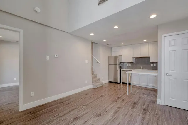a view of kitchen with refrigerator and wooden floor