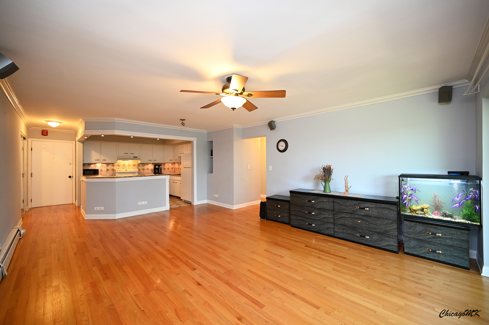2234 South Goebbert Road, Unit 422 Arlington Heights, IL 60005 - Photo 4 of 27 a view of a kitchen with kitchen island a sink wooden floor and a stove top oven