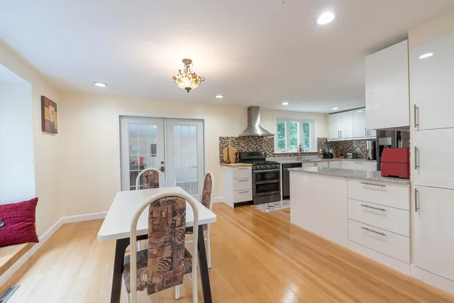 a kitchen with a refrigerator a stove a sink a dining table and chairs