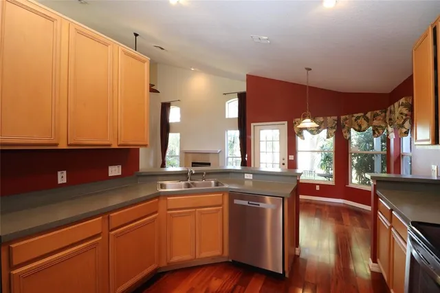 a kitchen with granite countertop a sink a counter space appliances and cabinets