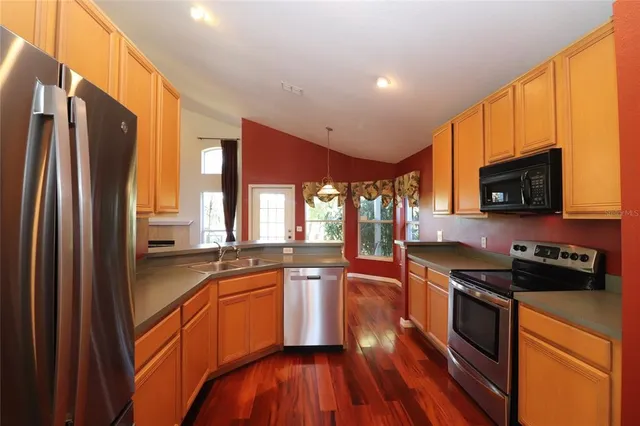 a kitchen with stainless steel appliances a refrigerator a stove a sink and a microwave