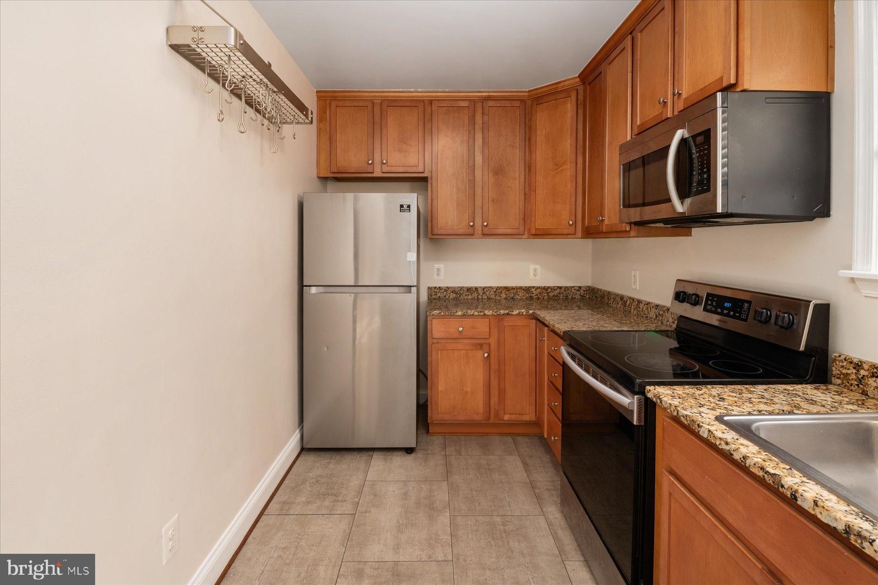 19 Post, Unit AVENUE 203 Laurel, MD 20707 - Photo 14 of 32 a kitchen with a sink a microwave a refrigerator and cabinets