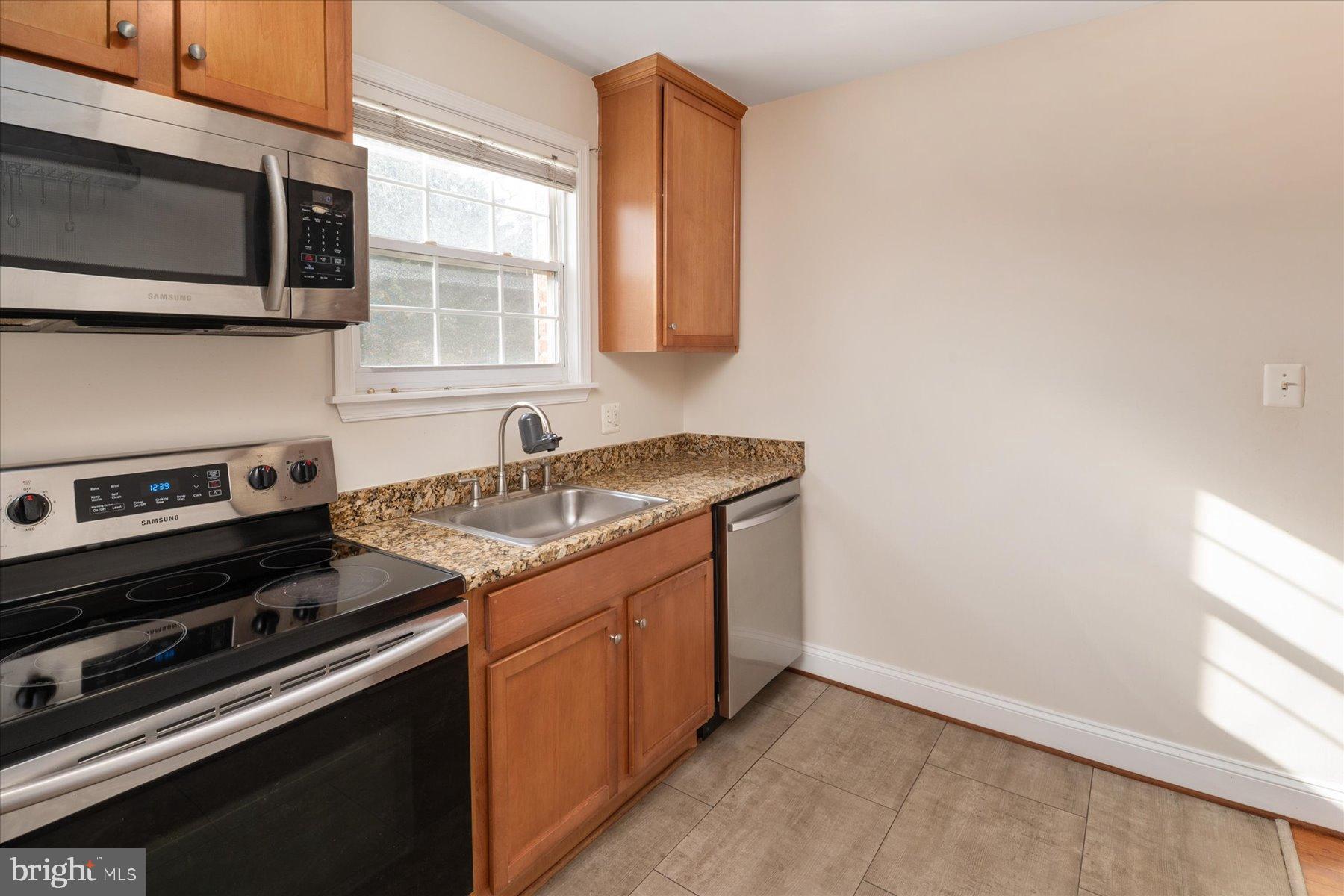 19 Post, Unit AVENUE 203 Laurel, MD 20707 - Photo 15 of 32 a kitchen with a stove and a microwave