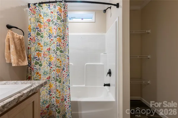 a bathroom with a granite countertop shower curtain and a sink